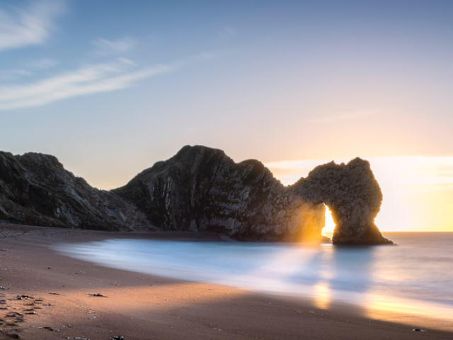 sunrise through durdle door arch