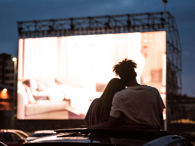 romantic couple sitting on the grass for outdoor cinema at lulworth castle