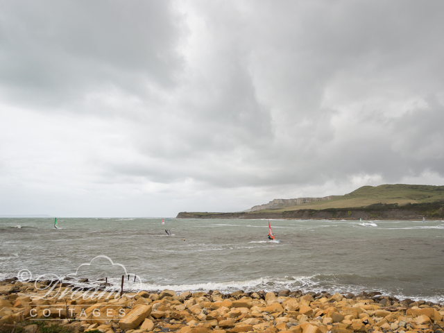 Windsurfers at Kimmeridge Bay on a stormy day