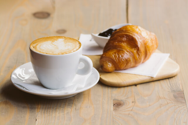 Coffee and crossiant on wooden table