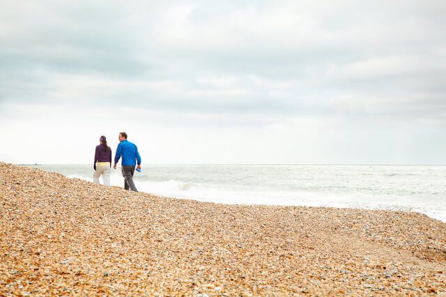 Couple walking along Chesil Beach
