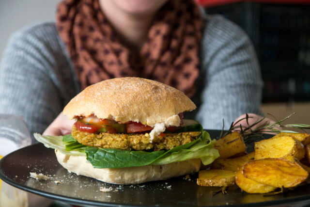 Vegan burger with woman in background