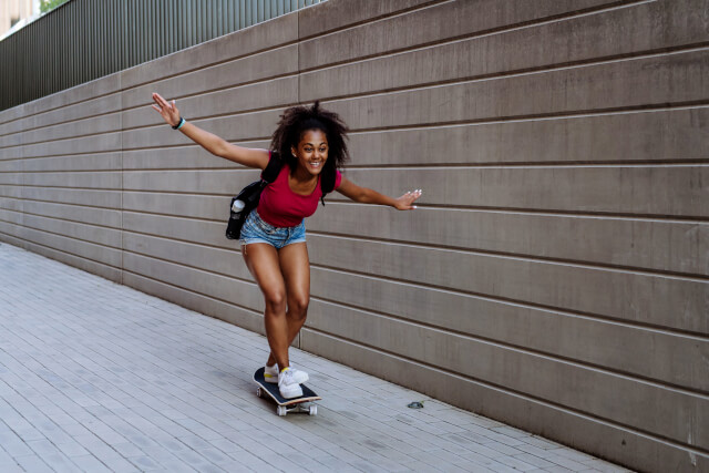 Teenage girl on skateboard near sports shop Weymouth